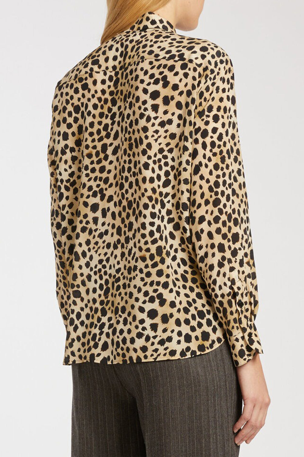 Leopard print blouse worn by a person on a white background