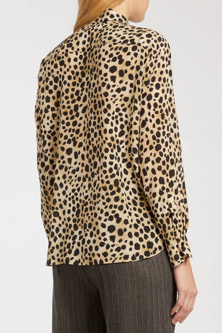 Leopard print blouse worn by a person on a white background
