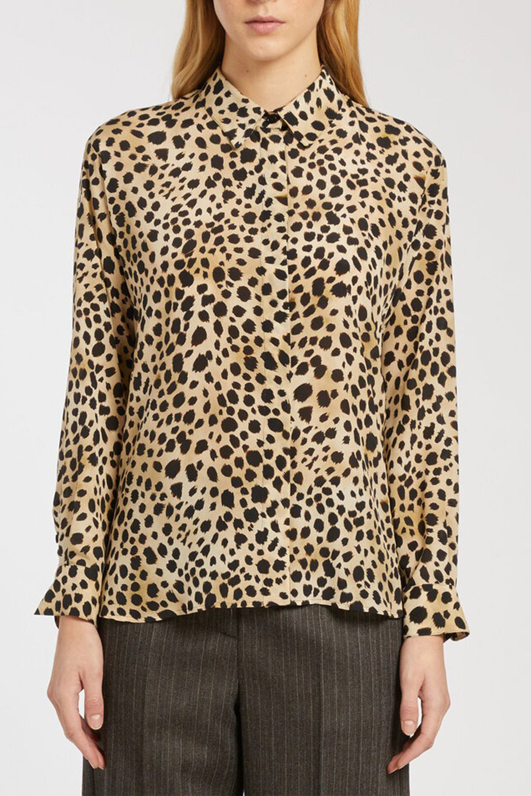 Leopard print blouse worn by a person on a white background