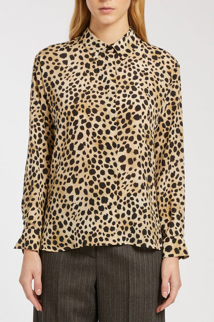 Leopard print blouse worn by a person on a white background