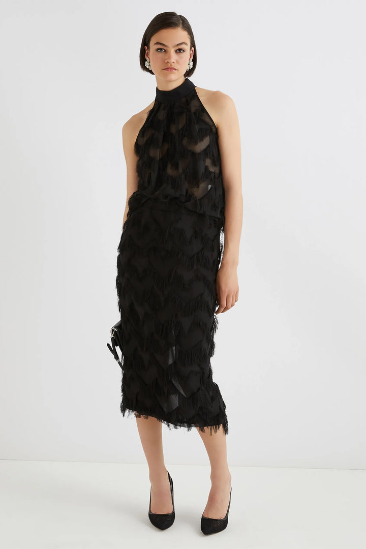 Woman wearing a black, ruffled dress on a white background