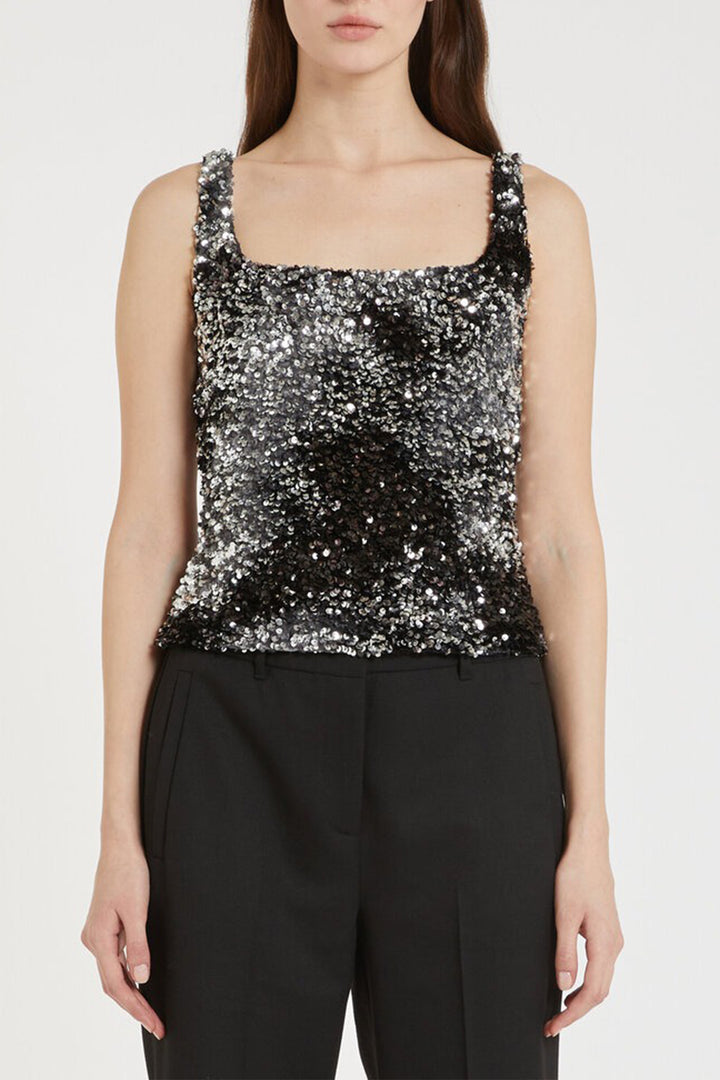 Woman wearing a black sequin top and black pants on a white background