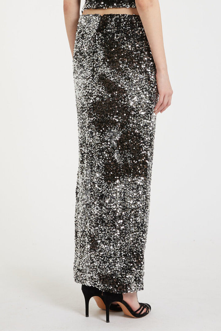Person wearing a long, sequined skirt on a white background
