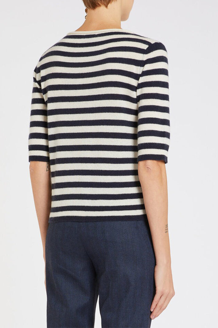 Person wearing a navy and white striped sweater on a plain background