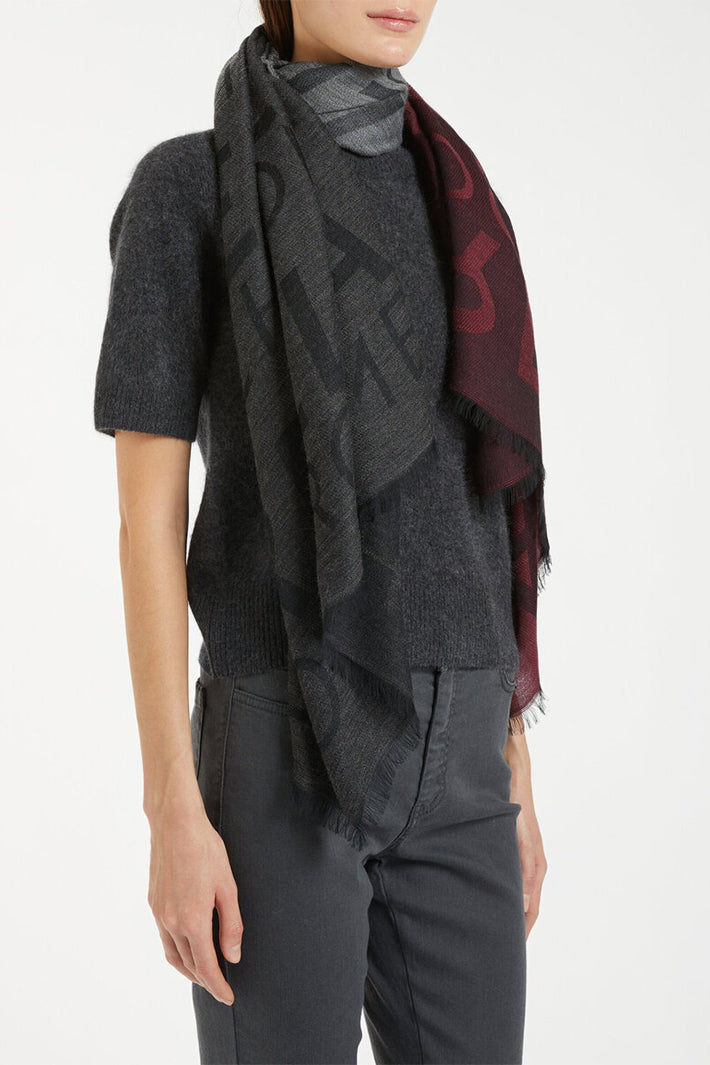 Person wearing a dark gray patterned scarf on a white background