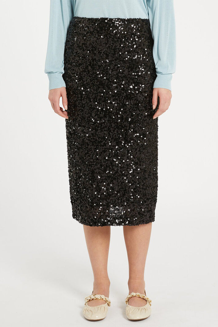 Person wearing a black sequin skirt on a white background