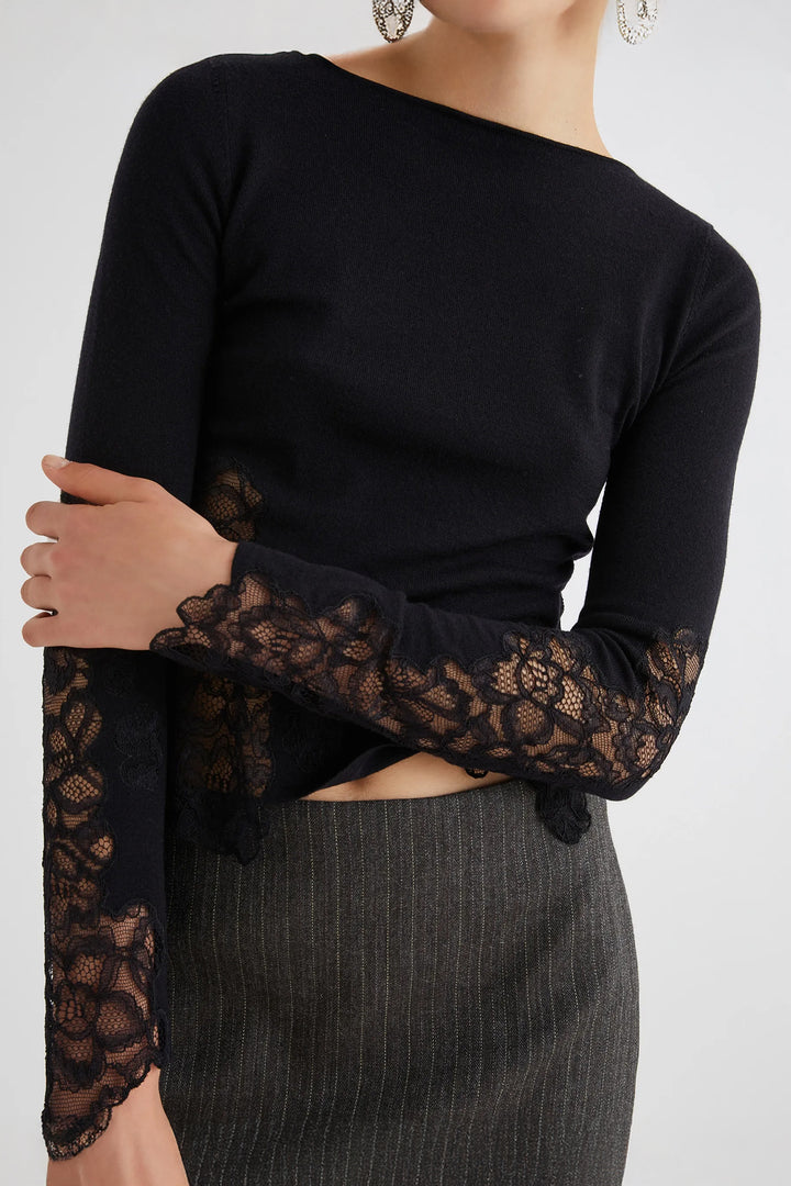 Black long-sleeve top with lace sleeves worn by a person on a white background