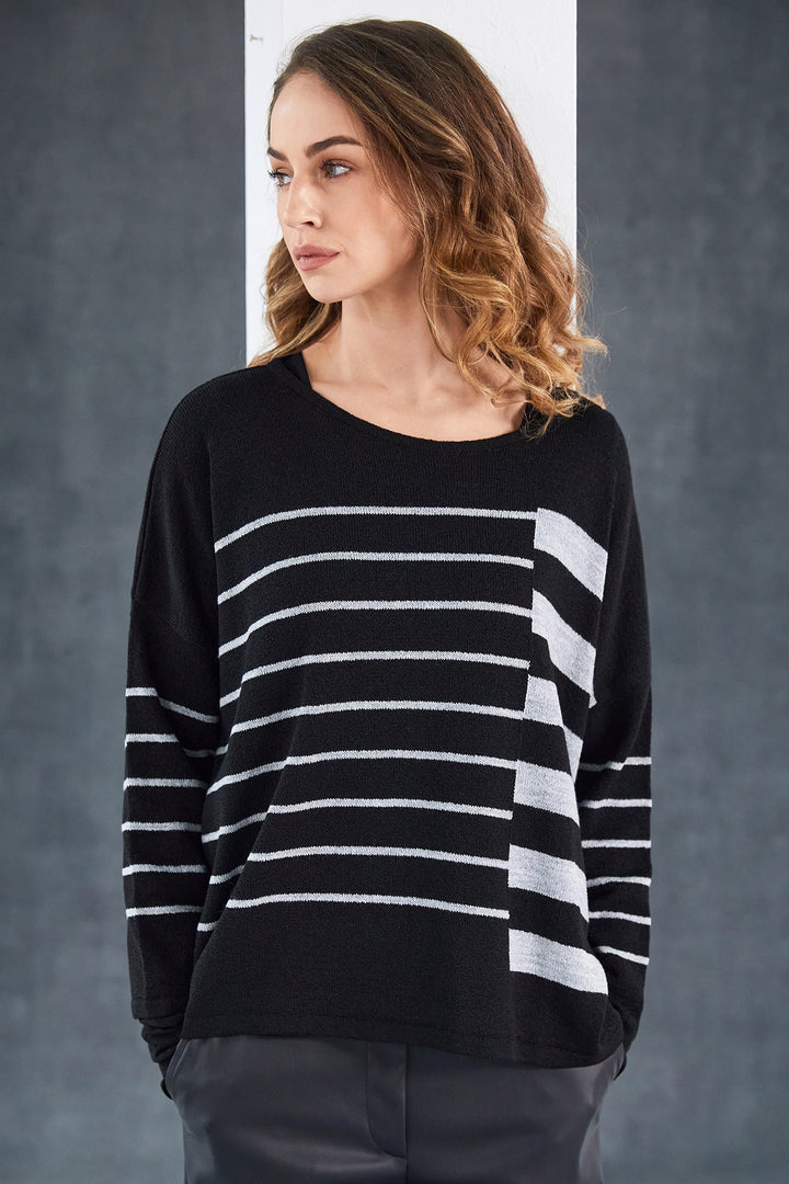 Woman wearing a black and white striped sweater against a gray background