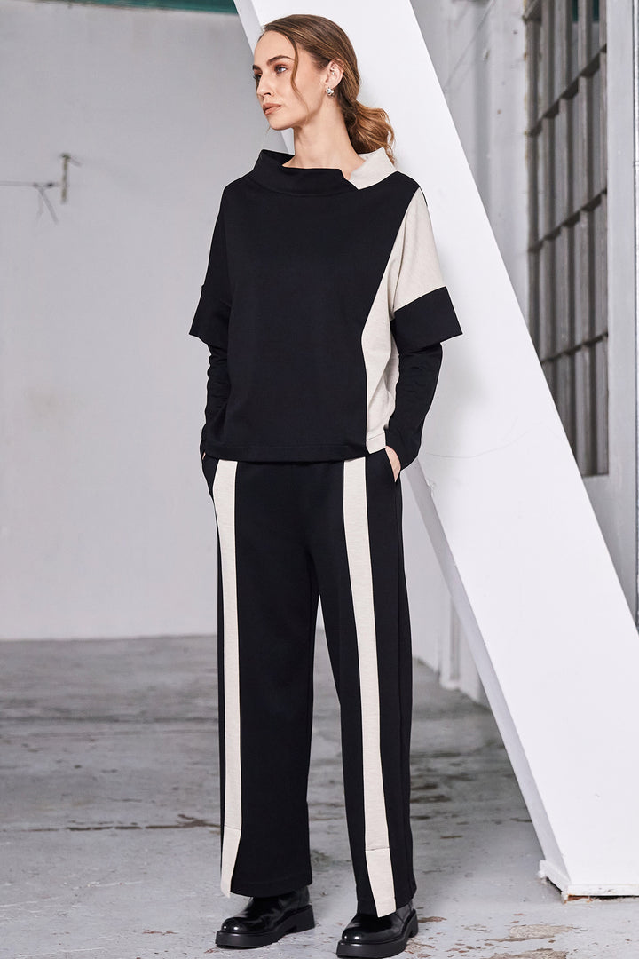 Woman wearing a black and white outfit with a white architectural structure in the background