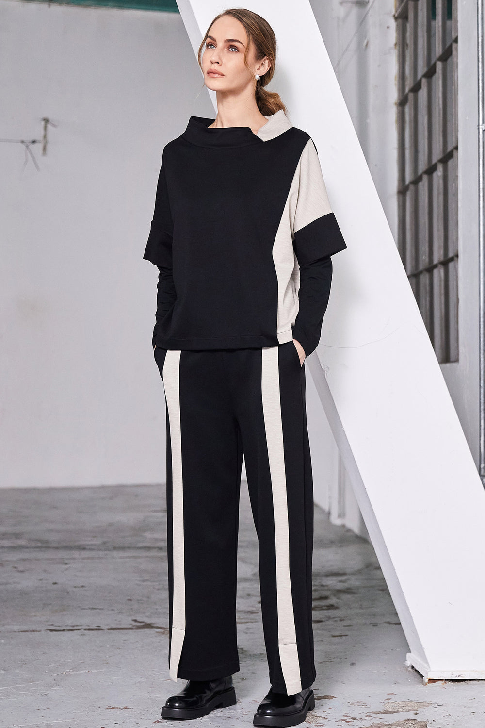 Woman wearing a black and white outfit with a white geometric background