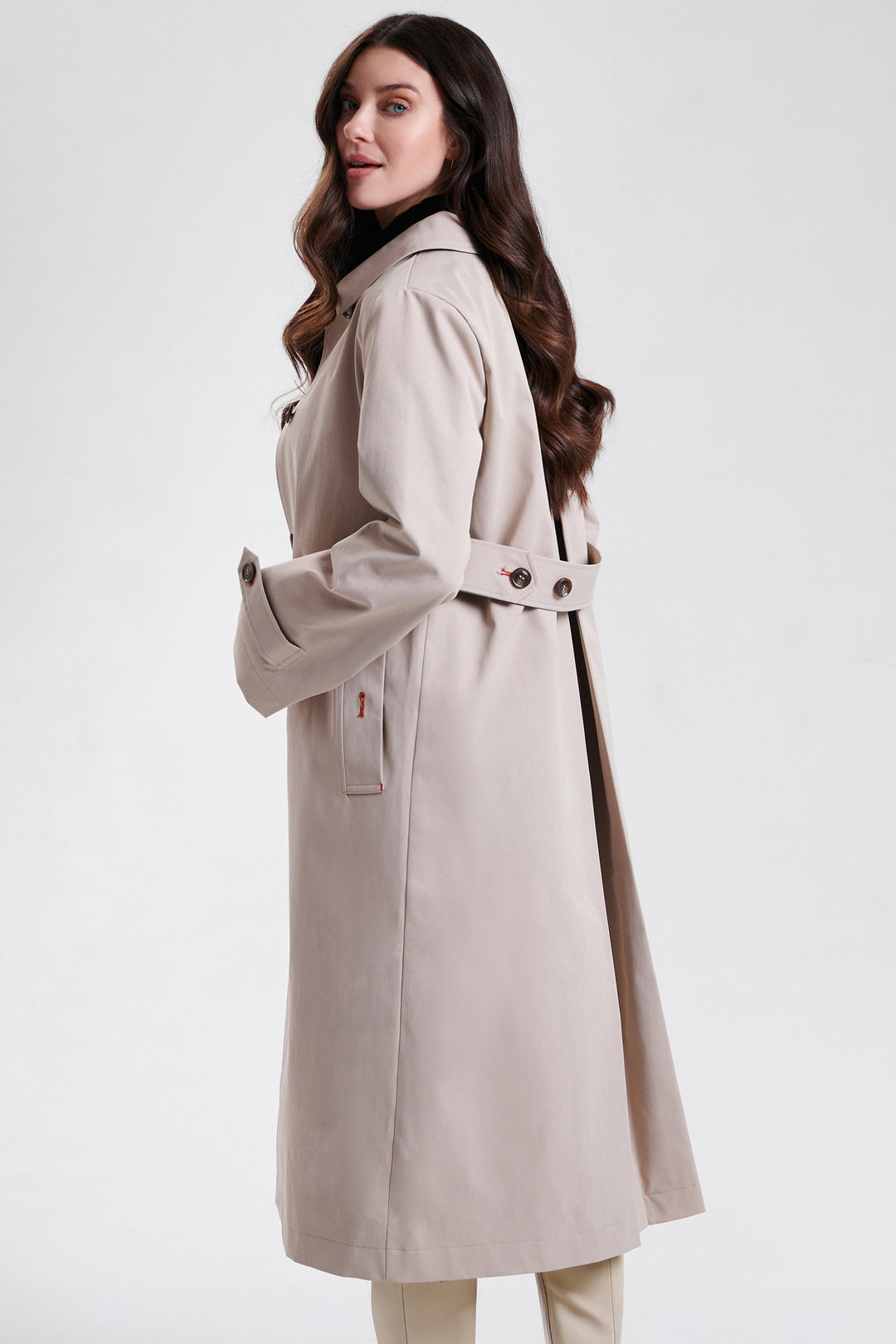 Woman wearing a beige trench coat on a white background