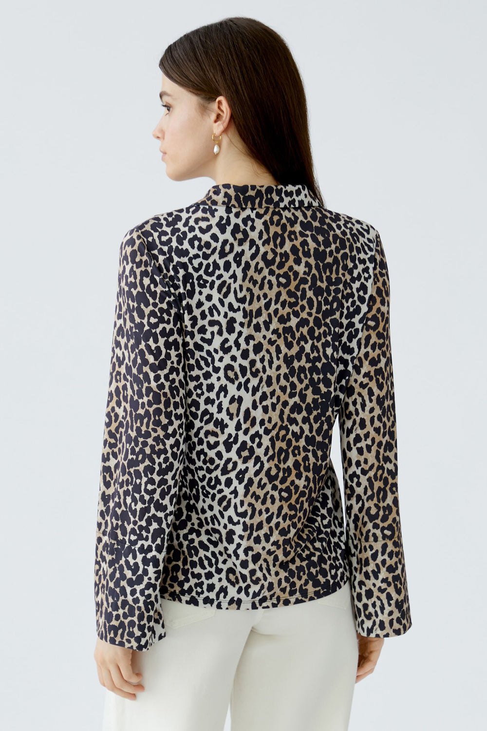 Woman wearing a leopard print blouse against a light gray background