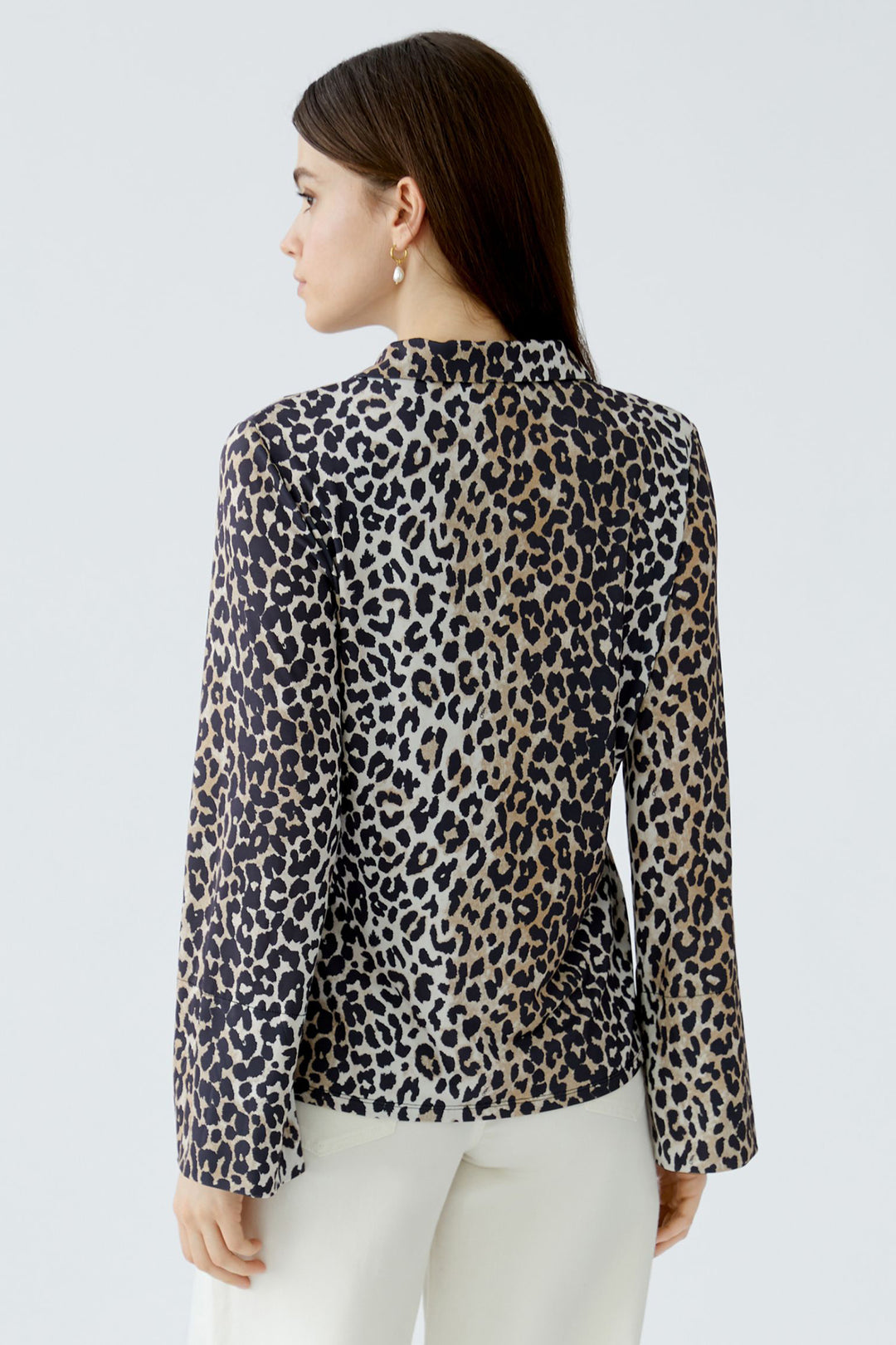 Woman wearing a leopard print blouse against a light gray background