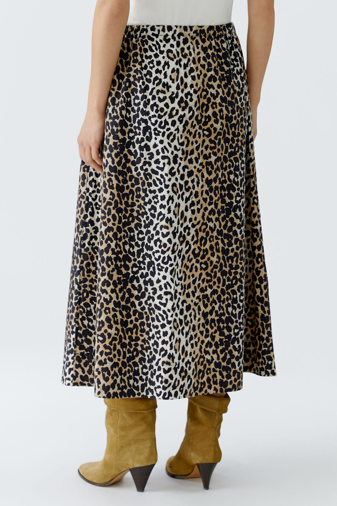 Person wearing a leopard print skirt with mustard yellow boots on a white background