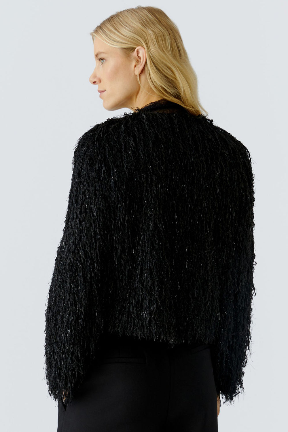 Person wearing a black textured jacket on a light gray background