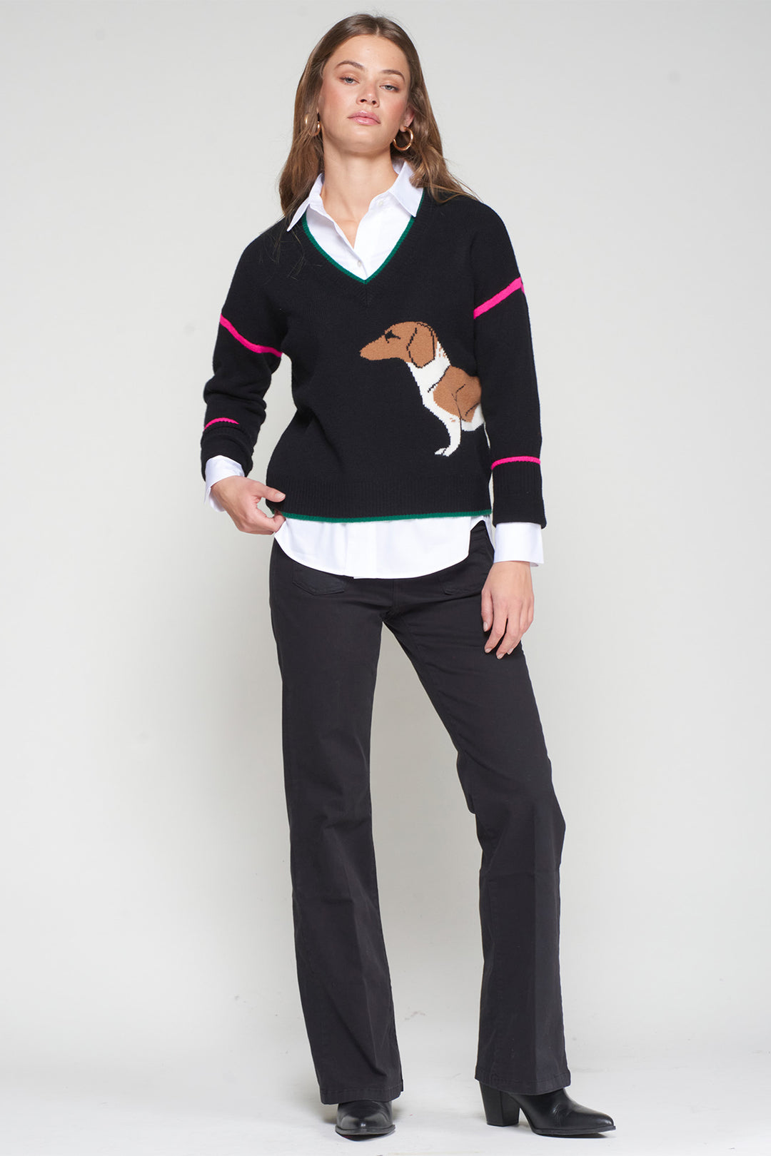 Woman wearing a black sweater with a dog design on a white background