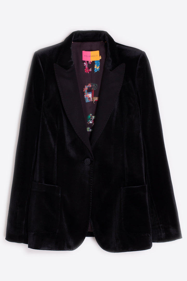 Black velvet blazer with a colorful shirt underneath on a white background