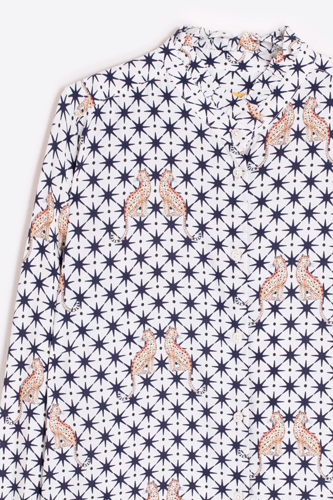Shirt with a pattern of stars and abstract shapes on a white background