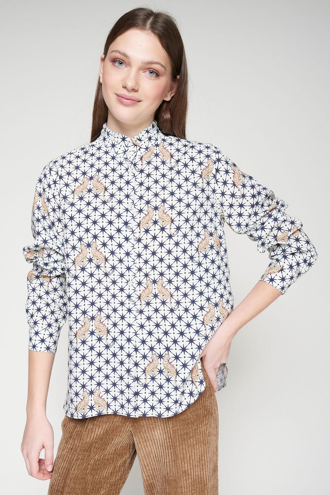 Woman wearing a patterned shirt with a plain background