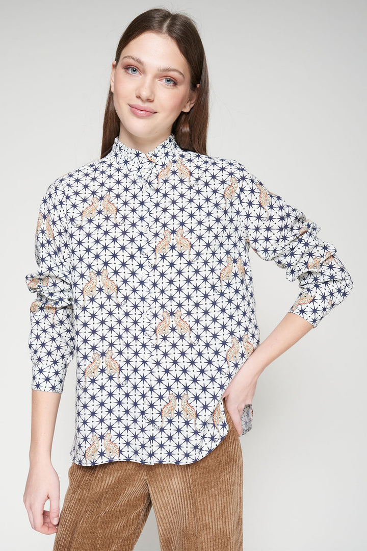 Woman wearing a patterned shirt with a plain background