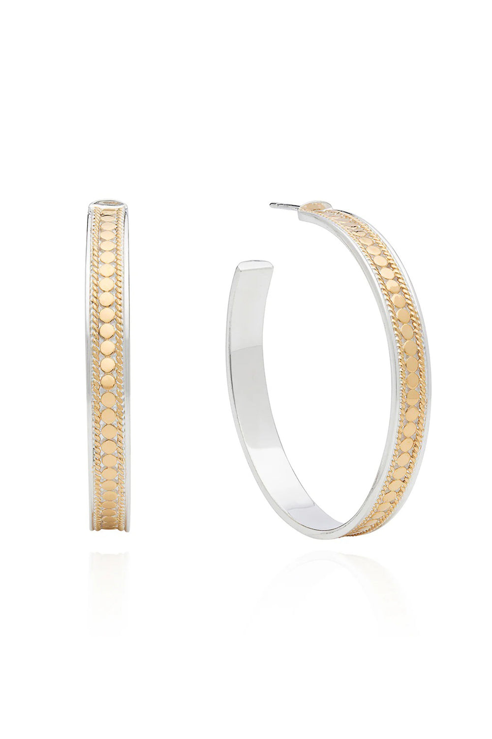 Two hoop earrings, one gold and one silver, on a white background