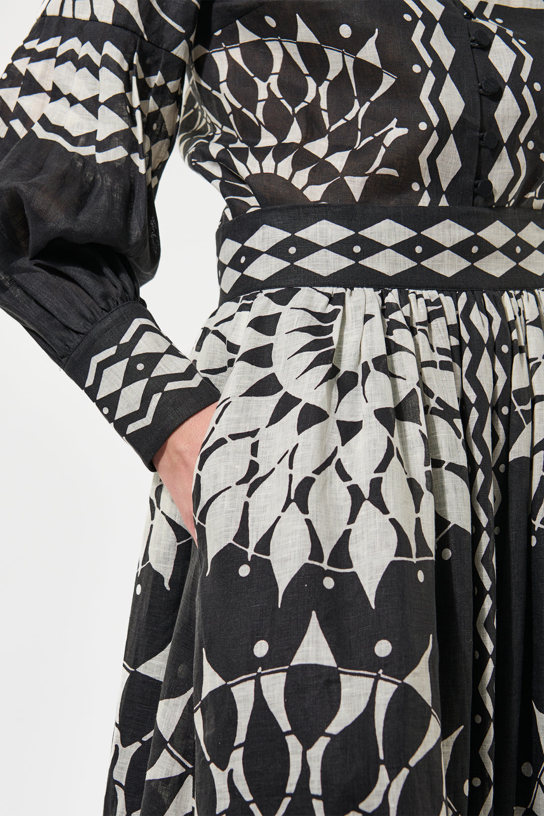 Black and white patterned dress with long sleeves on a plain background