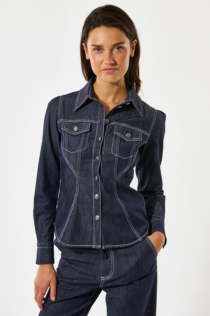 Woman wearing a dark blue denim jacket and pants on a white background