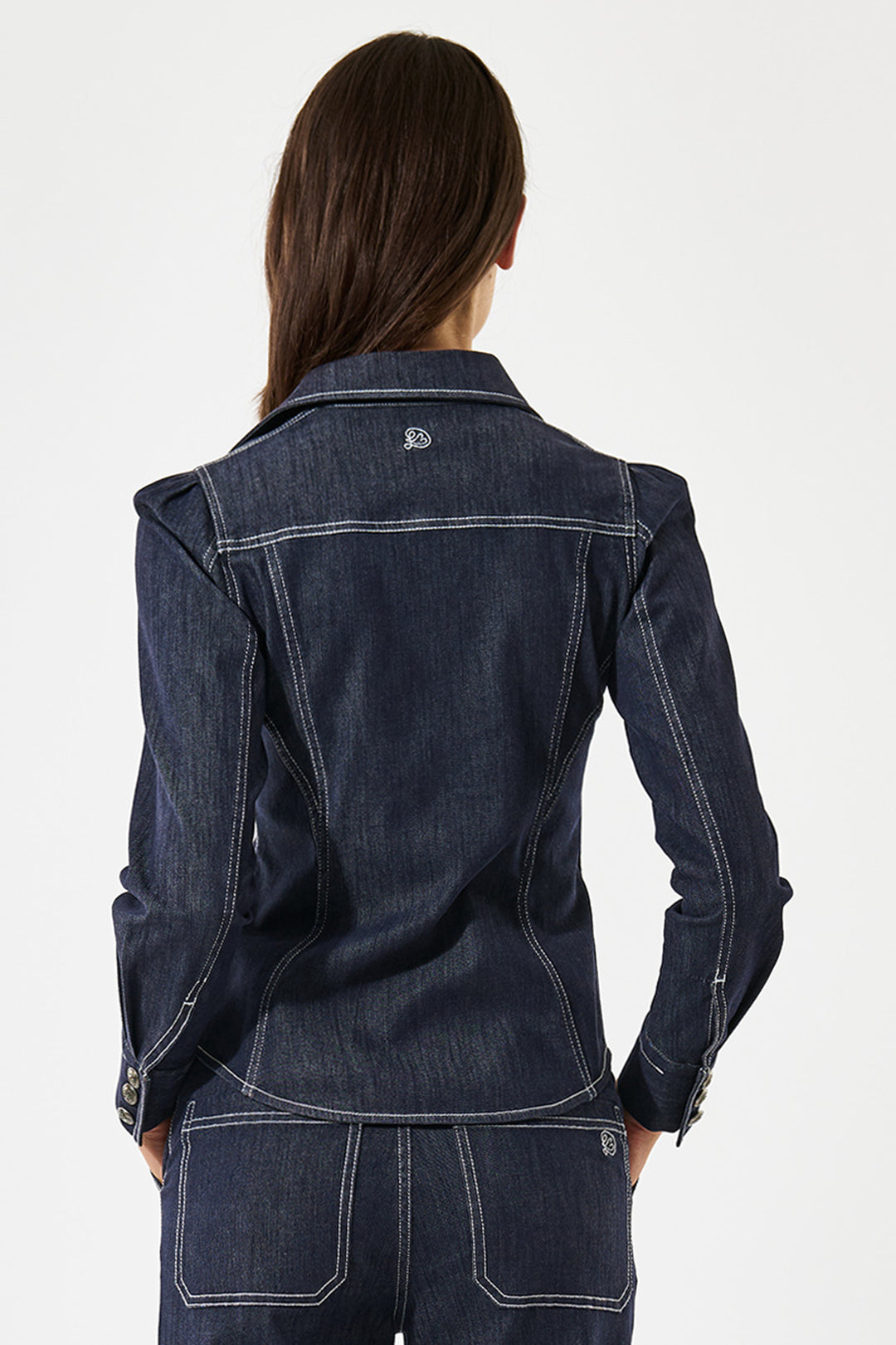 Person wearing a dark blue denim jacket on a white background