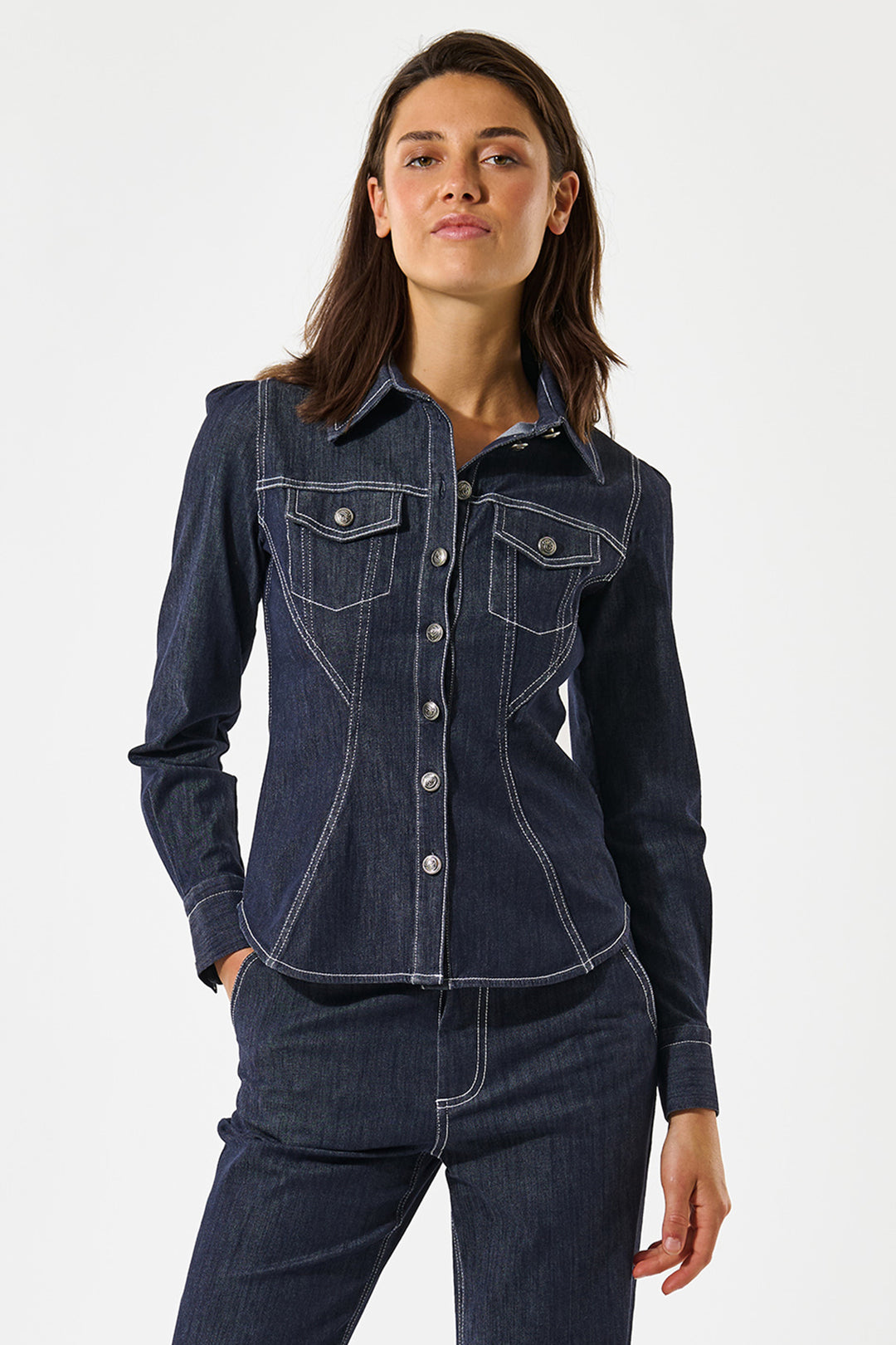 Woman wearing a dark blue denim jacket and pants on a white background
