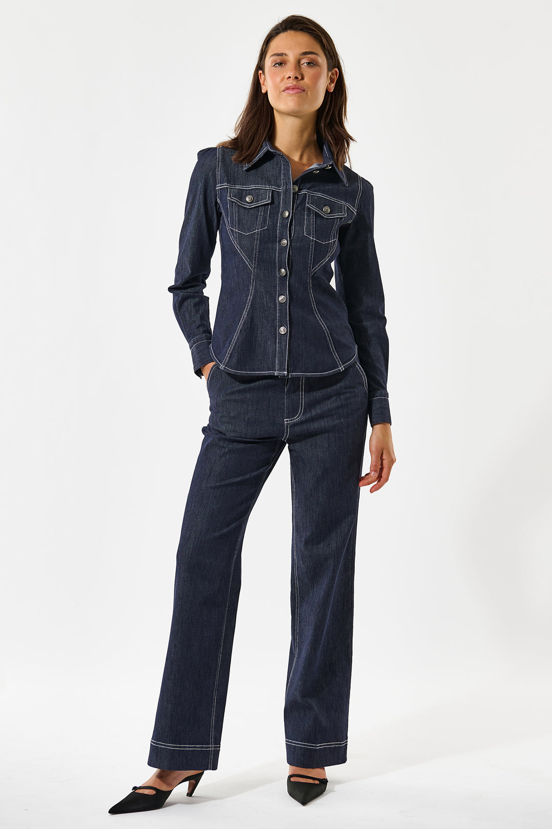 Woman wearing a dark blue denim outfit on a white background