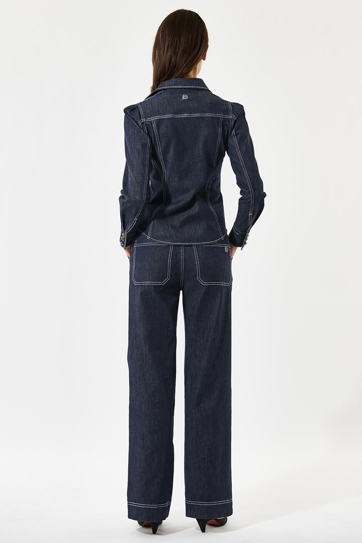 Person wearing a dark blue denim jacket and pants on a white background