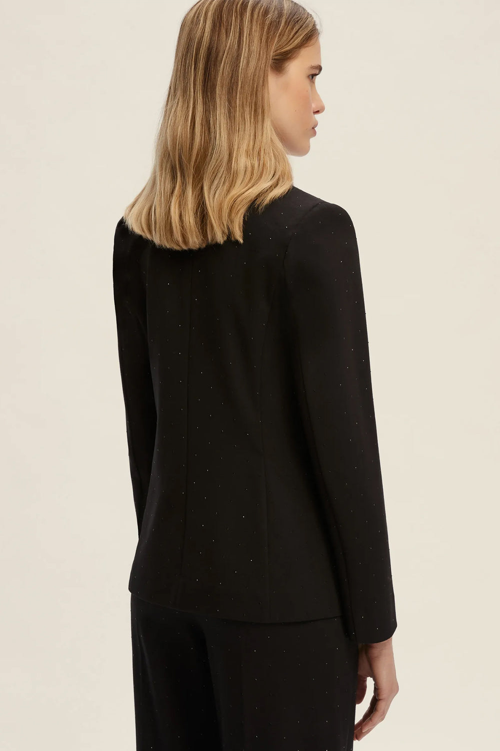 Woman wearing a black outfit on a beige background