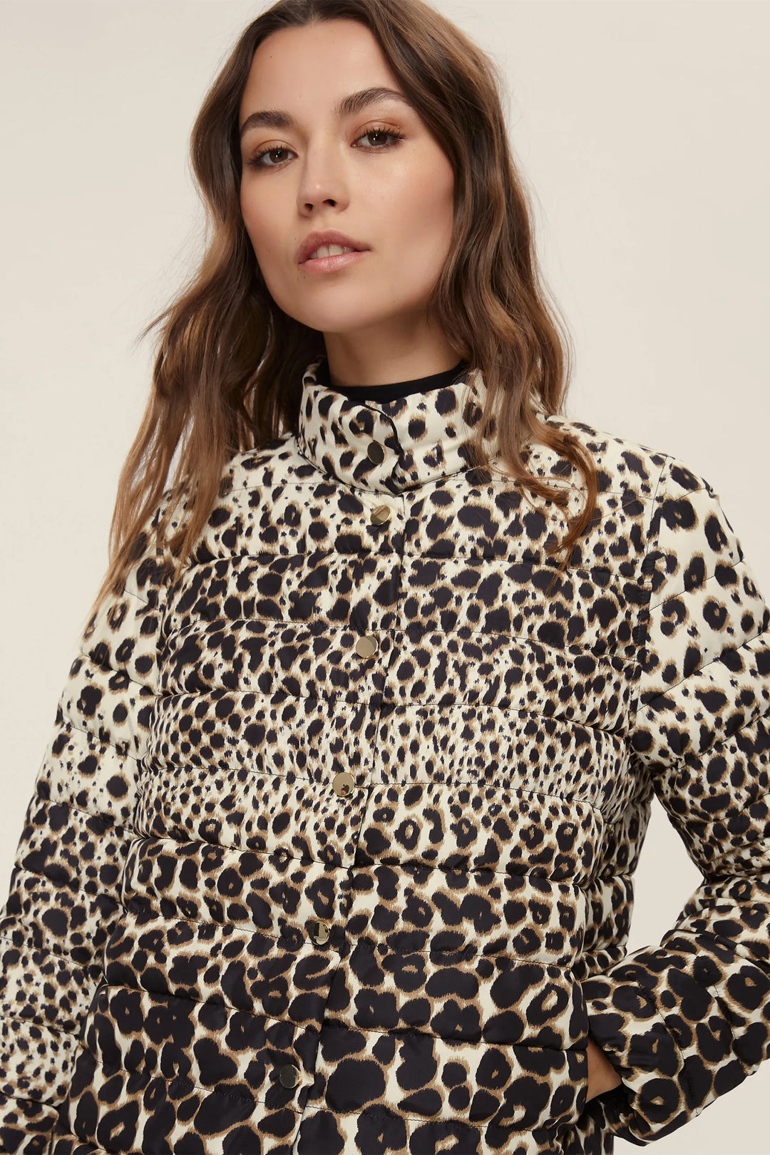 Woman wearing a leopard print top against a neutral background