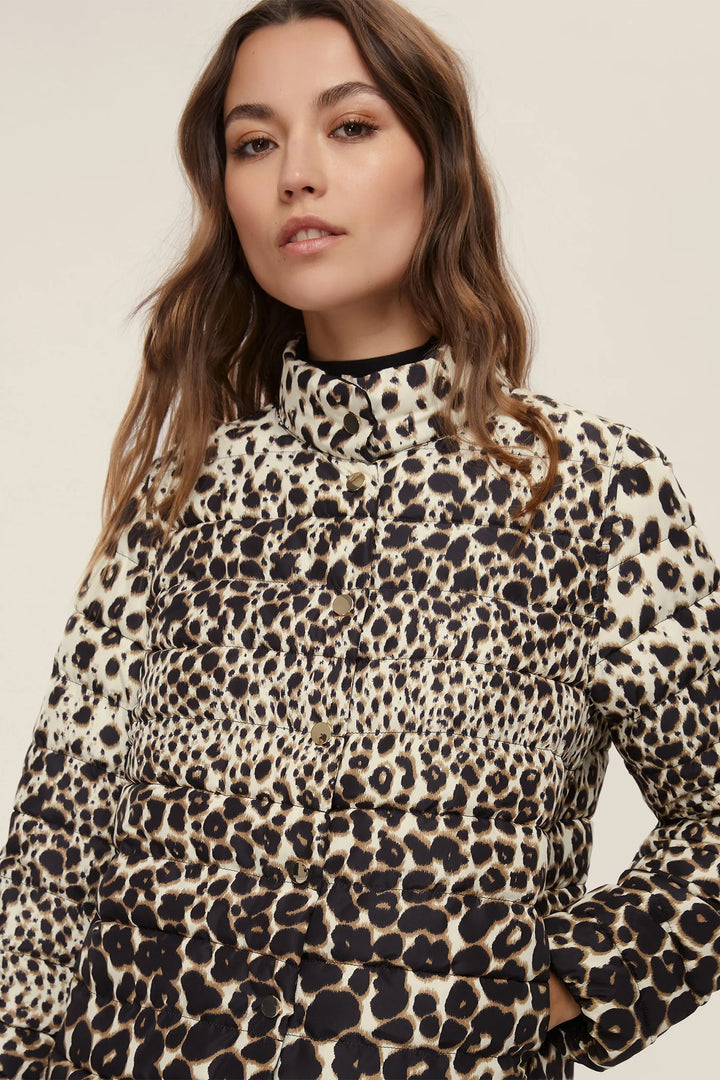 Woman wearing a leopard print top against a neutral background