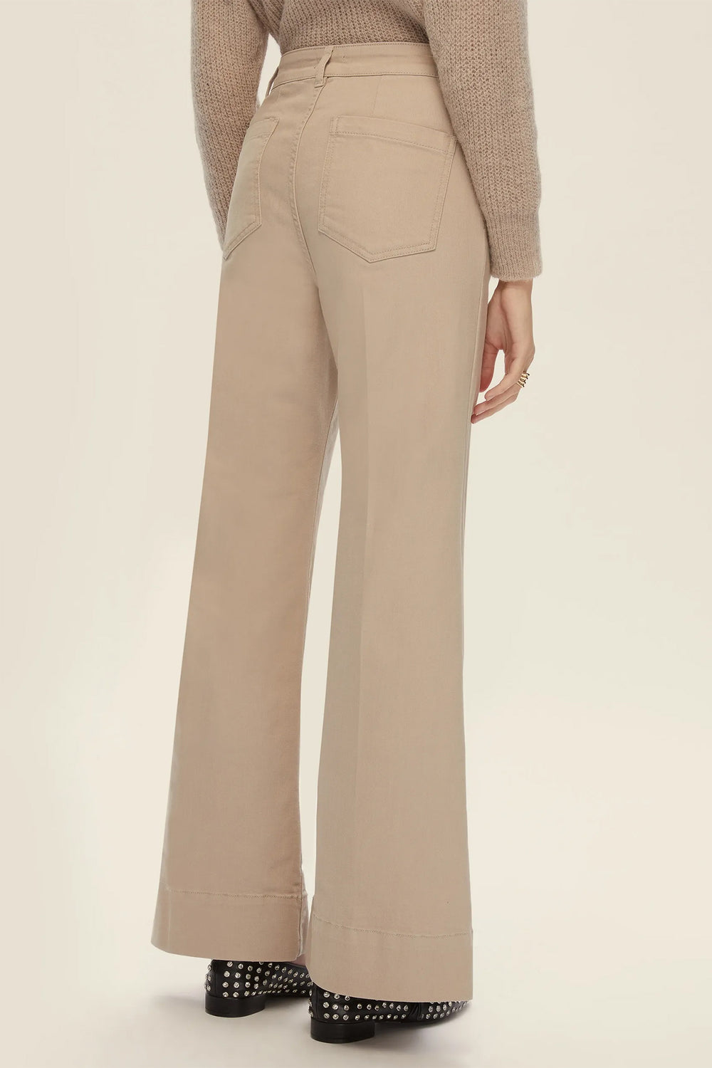 Beige wide-leg pants worn by a person on a beige background