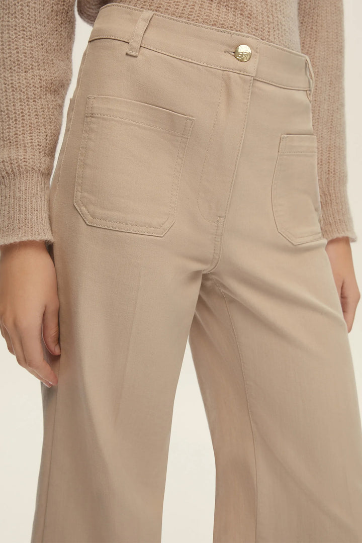 Beige pants worn by a person on a plain background