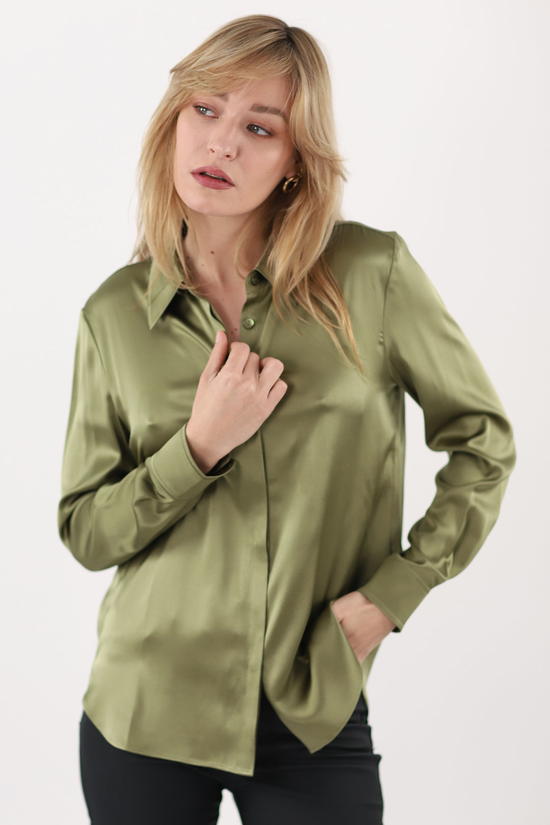 Woman wearing a green satin shirt on a white background
