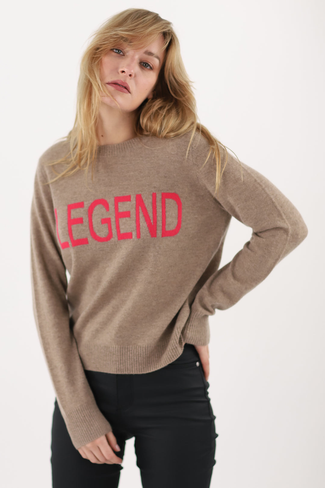 Woman wearing a brown sweater with 'LEGEND' in red text on a white background