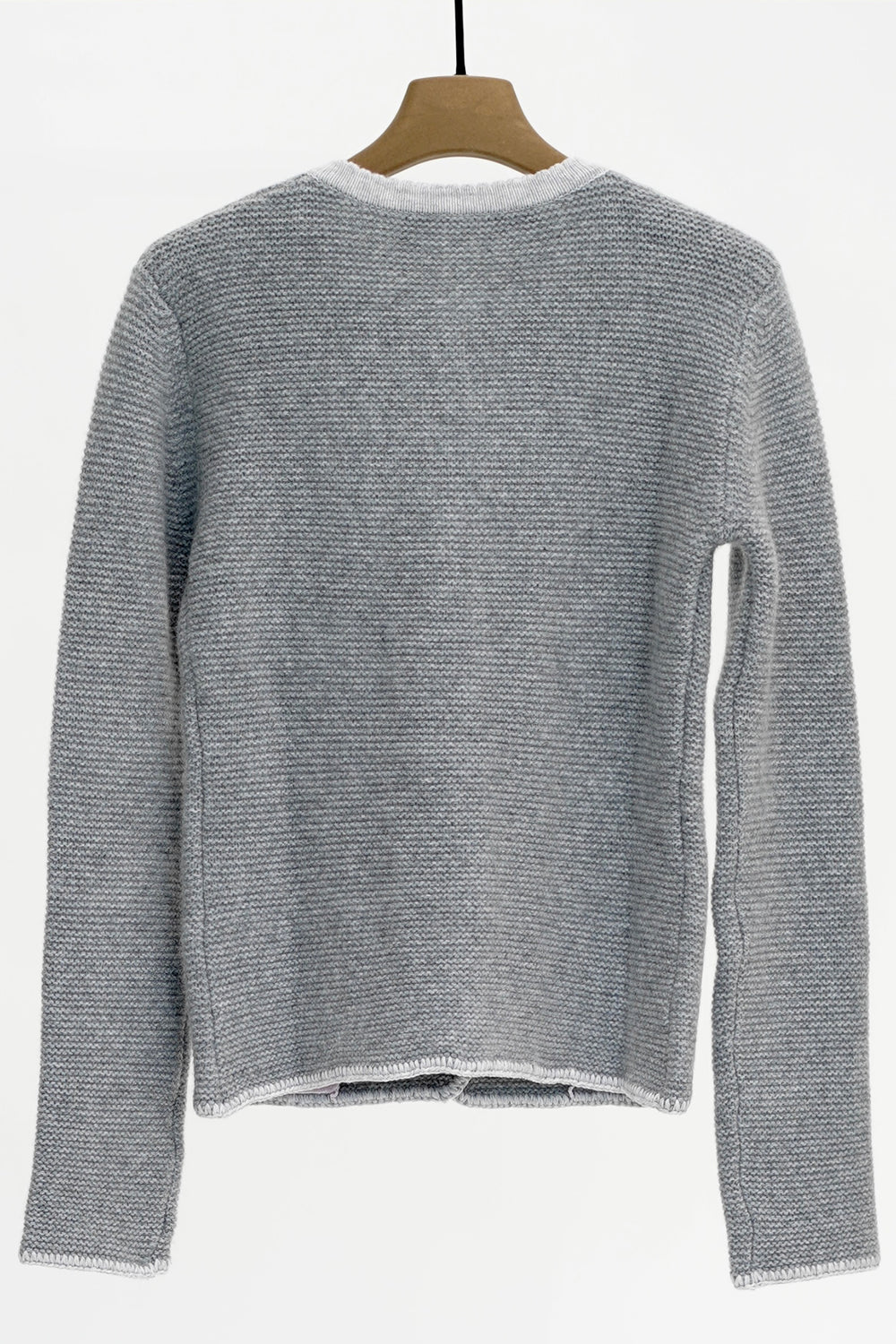 Gray knitted sweater on a hanger against a white background