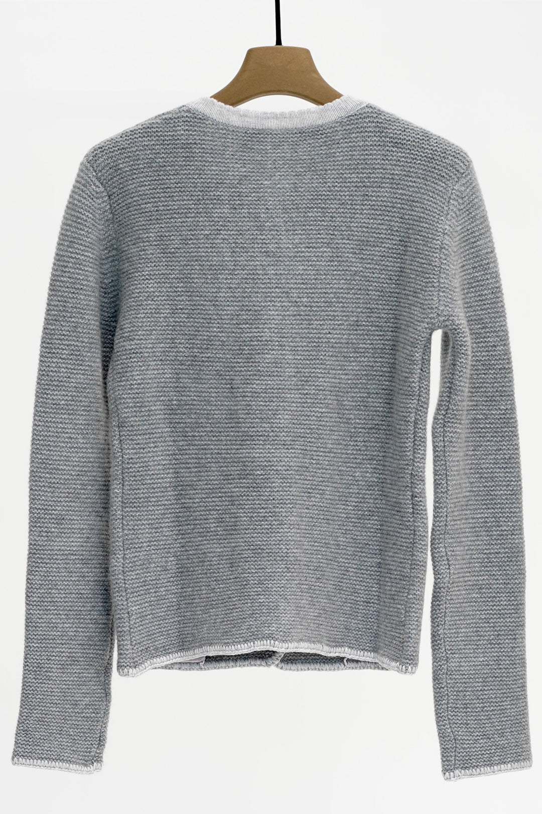 Gray knitted sweater on a hanger against a white background