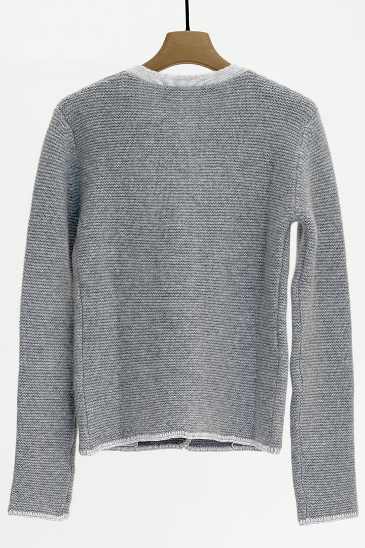 Gray knitted sweater on a hanger against a white background