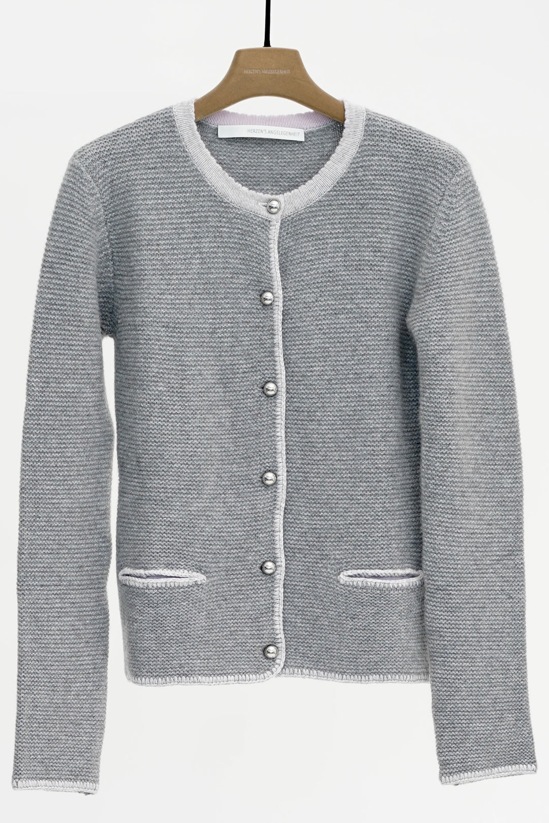 Gray knitted cardigan on a wooden hanger against a white background