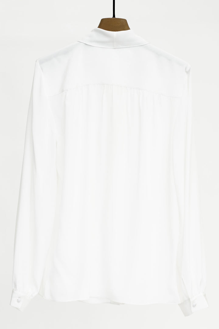 White shirt on a hanger against a white background