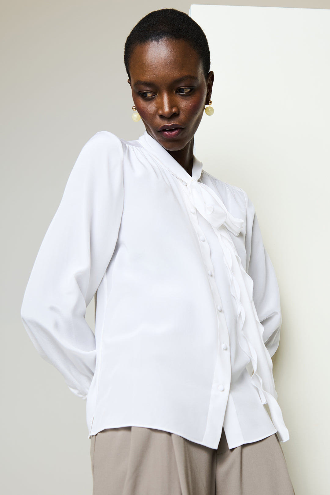 Woman wearing a white blouse with a plain background