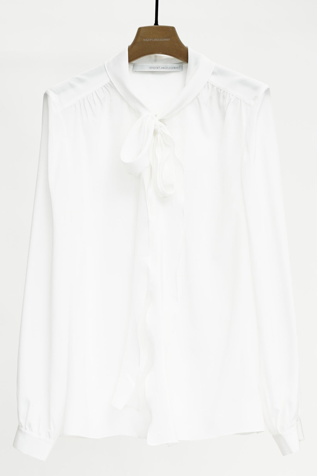 White shirt on a hanger against a white background