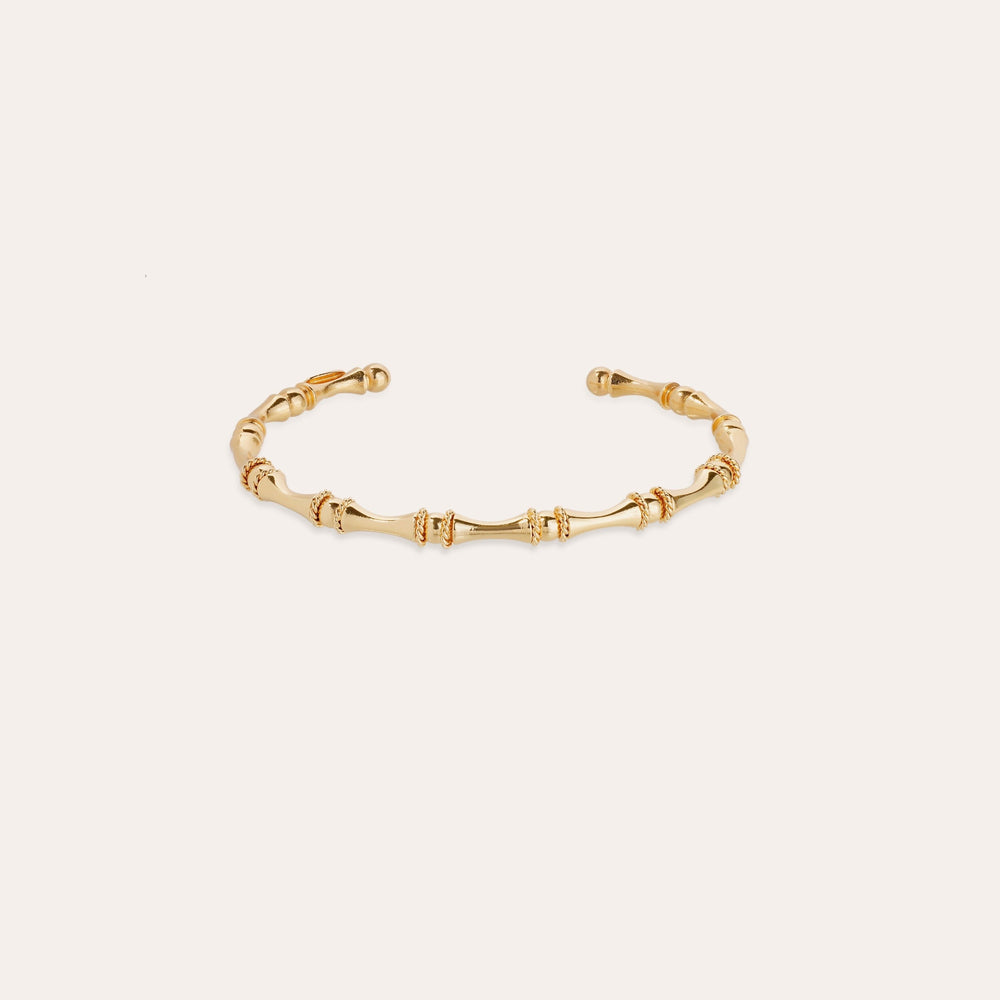 Gold bracelet on a light beige background