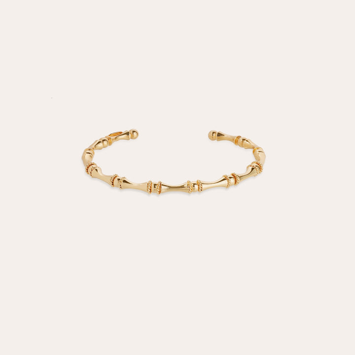 Gold bracelet on a light beige background
