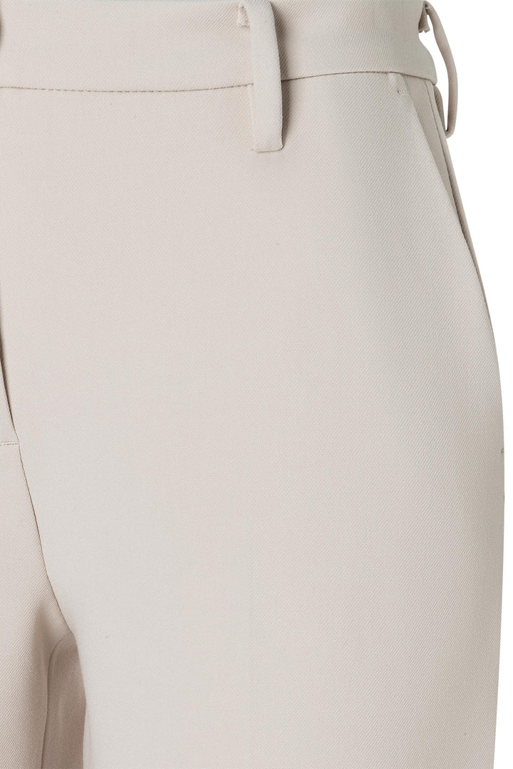 Close-up of beige pants with a belt on a white background