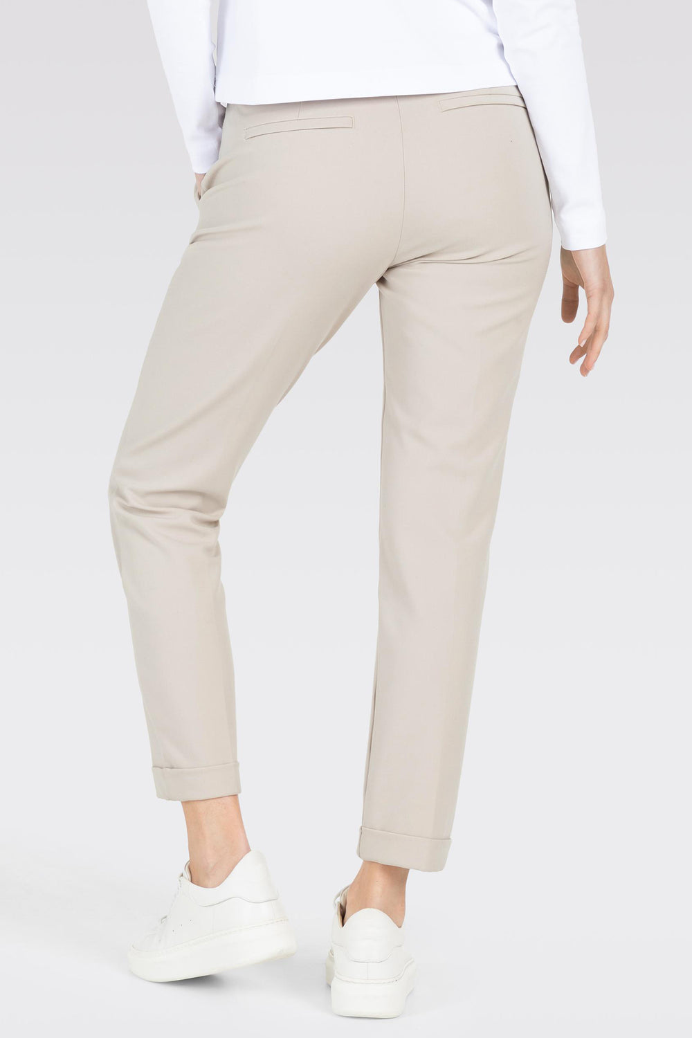 Beige pants worn by a person on a white background