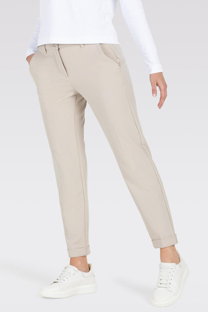 Beige pants worn by a person on a white background